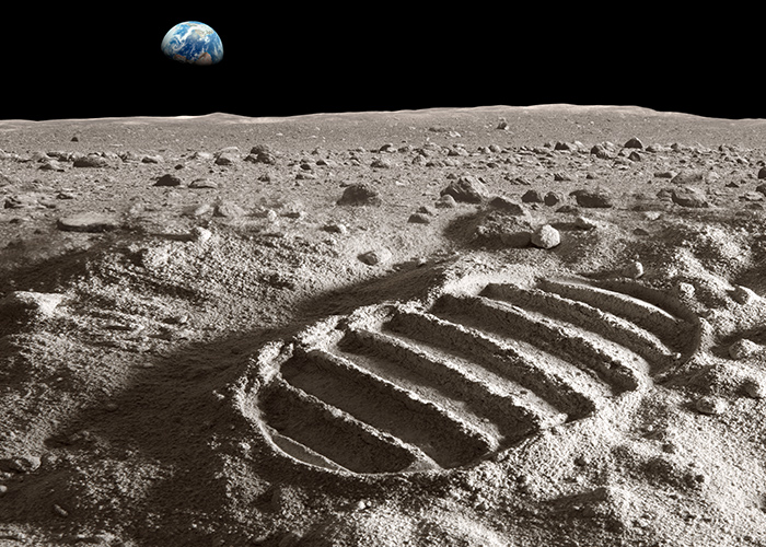 Footprint on moon with Earth over the horizon